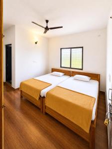 a bedroom with two beds and a ceiling fan at hotel raj palace in Londa