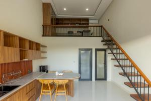 a kitchen with a wooden table and a staircase at DC 08 Residence in Dalung