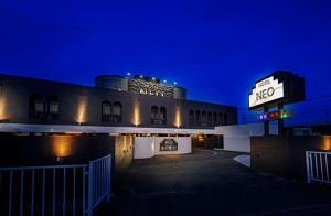 a motel with a sign in front of it at night at Hotel NEO in Honjo