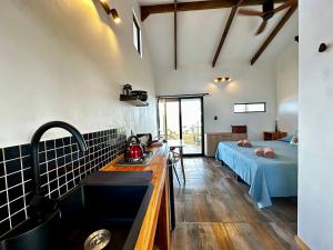 a kitchen with a sink and a bed in a room at Cabañas & Hostal Tojika in Hanga Roa