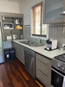 a kitchen with a sink and a counter top at The Cooby in Spearwood