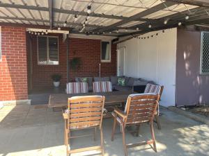 a wooden table and two chairs on a patio at The Cooby in Spearwood