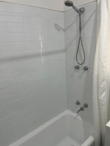 a bathroom with a shower with a white tub at The Cooby in Spearwood +16 photos