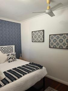 a bedroom with a bed and a ceiling fan at The Cooby in Spearwood