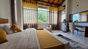 a bedroom with a large bed with a desk and windows at Kandy home in Kandy
