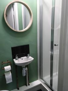 a bathroom with a sink and a mirror and a shower at Self Catering Cellb Ffestiniog in Blaenau-Ffestiniog