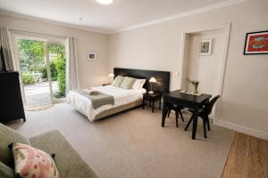 a bedroom with a bed and a desk and a bed and a table at Alpine Cardrona by Aotearoa Escapes in Cardrona