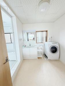 a laundry room with a washing machine and a sink at 红尘会馆 in Kishiwada +10 photos