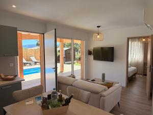 a living room with a couch and a table at CALA CORSICA - Villas 5 Etoiles T5 Piscine privée - Villa T4 Piscine privée chauffée - Villa T3 Piscine partagée - Internet Fibre - Entièrement Climatisée à Lecci de Porto-Vecchio Cala Rossa in Lecci