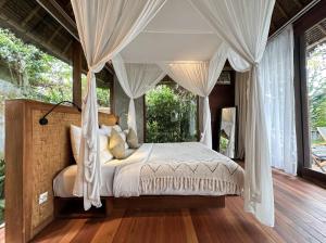 a bedroom with a bed with a canopy at ZIN Berawa Villas & Bungalows in Canggu +116 photos