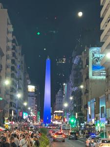 a crowd of people on a busy city street at night at Hostal 2 in Buenos Aires +6 photos