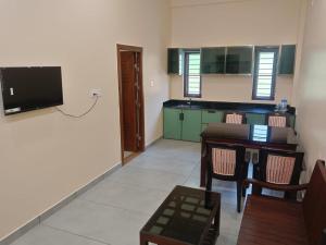 a living room with a table and a tv on the wall at Hotel Sindoor Inn in Parli