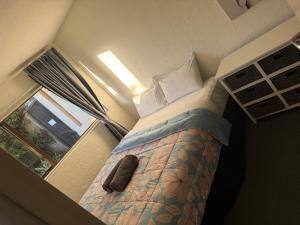 a bed in a small room with a window at AAA Mana Motel in Porirua