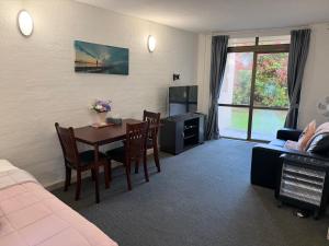 a living room with a table and a couch at AAA Mana Motel in Porirua