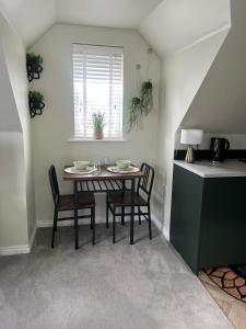 a dining room with a table and chairs and a window at Loft Studio in Davenham +3 photos