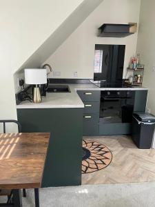 a kitchen with a stove and a table with a lamp at Loft Studio in Davenham
