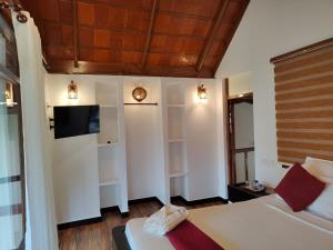a bedroom with a bed and a tv on the wall at Les 3 Elephants in Cherai Beach