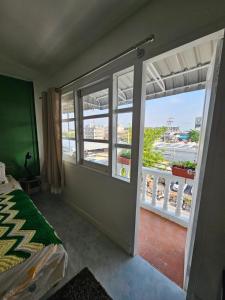 a room with a balcony with a bed and a window at Papa house in Pak Kret +2 photos