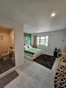 a bedroom with a bed and a bathroom at Papa house in Pak Kret