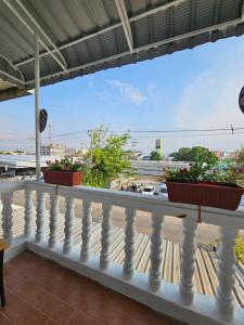 a balcony with two potted plants on a white railing at Papa house in Pak Kret