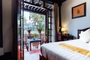 a bedroom with a bed and a view of a patio at Ban Lakkham River View in Luang Prabang