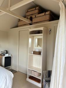 a bedroom with a white cabinet with baskets on the ceiling at Tswalu in Raglan