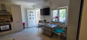 a kitchen with a table and chairs in a room at Studio Apartman DORA in Senj