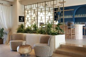 a room with two chairs and a counter with plants at Alai Crete, a Tribute Portfolio Resort in Stalís
