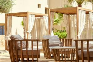 a patio with chairs and a bed and a table at Alai Crete, a Tribute Portfolio Resort in Stalís
