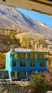 a blue building with a mountain in the background at Kepal Inn Hotel and Restaurant in Holshāl