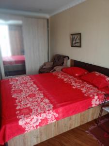 a bedroom with a large bed with a red blanket at Сергей Сергеевич in Akhaltsikhe