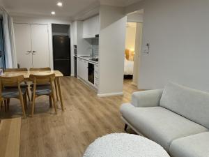a living room with a couch and a table at Chay's Guest House in Coffs Harbour +7 photos