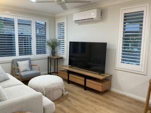 a living room with a large flat screen tv at Chay's Guest House in Coffs Harbour