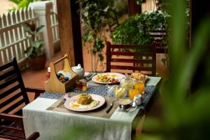 a table with two plates of food on it at Ban Lakkham River View in Luang Prabang