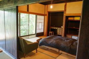 a bedroom with a bed and a desk and a tv at 0site house in Hokuto