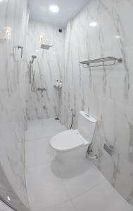 a white bathroom with a toilet and a shower at Skyinn omadhoo in Omadhoo +74 photos