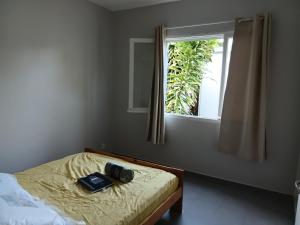 a bedroom with a bed with a window and a camera on it at App F4 Kone centre RDC Tel 7O 55 O8 in Koné