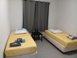 two beds in a room with yellow sheets at App F4 Kone centre RDC Tel 7O 55 O8 in Koné