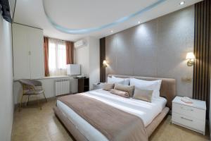 a bedroom with a large bed and a chair at Time Boutique Hotel in Yerevan +58 photos