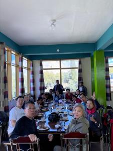 a group of people sitting at a table in a restaurant at Kepal Inn Hotel and Restaurant in Holshāl