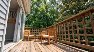 two chairs and a table on a wooden deck at Corporate Retreat - Stylish 2BR Condo with Pool, Balcony & Fast Wi-Fi, Minutes from Downtown Wilmington in Wilmington