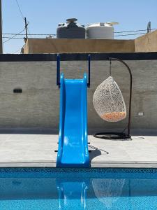 a blue plastic chair next to a swimming pool at Al Maha Farm in Jerash +6 photos