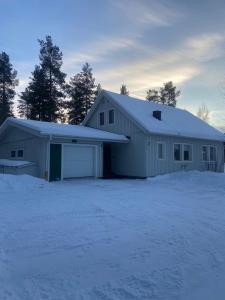 a large white barn with snow on the ground at Villa Mio in Vidsel +9 photos