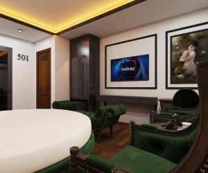 a bedroom with a bed and green chairs at Villa Victoria Me Tri in Hanoi