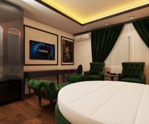 a hotel room with a large bed and two chairs at Villa Victoria Me Tri in Hanoi