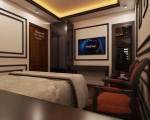 a bedroom with a bed and a tv on the wall at Villa Victoria Me Tri in Hanoi