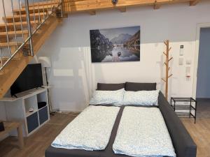 a bedroom with a bed and a staircase at SchwalbenNest Pfeifers OdenwaldNest in Rimbach