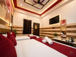 a hotel room with two beds and a flat screen tv at K D Dham Hotel-Near Prem Mandir1 in Vrindāvan