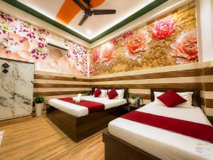 two beds in a room with flowers on the wall at K D Dham Hotel-Near Prem Mandir1 in Vrindāvan