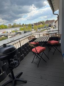 a balcony with a table and chairs and a grill at StorchenNest Pfeifers OdenwaldNest in Rimbach